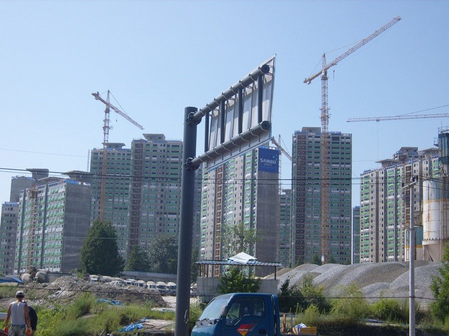 아파트 건설 현장 주변에 안전하게 세워진 대형 도로표지판 지주 뒷모습