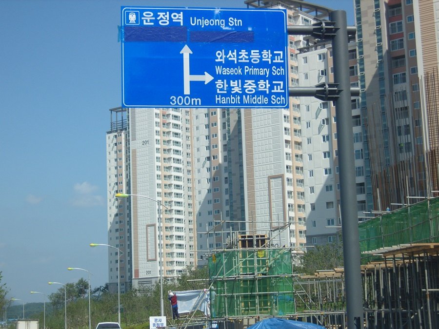 건설 현장 비계구조물 앞 도로에 수평을 맞춰 설치된 운정역 방면 표지판